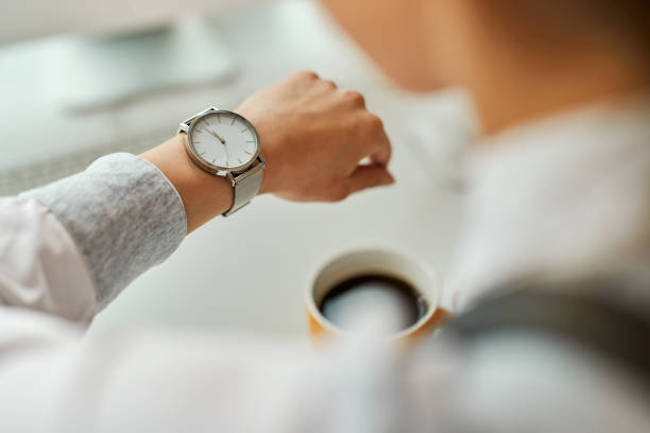 腕時計を確認する女性の手元　コーヒー
